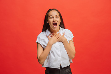 Image showing Beautiful woman looking suprised isolated on red