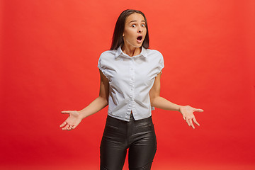 Image showing Beautiful woman looking suprised isolated on red