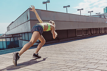 Image showing Pretty sporty woman jogging at city