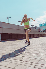 Image showing Pretty sporty woman jogging at city