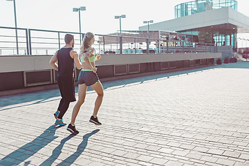 Image showing Pretty sporty woman and man jogging at city