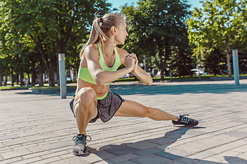 Image showing Fit fitness woman doing stretching exercises outdoors at park