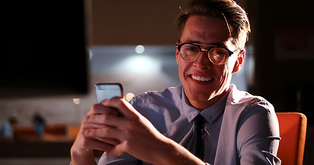 Image showing man using mobile phone in dark office