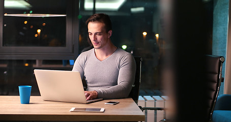 Image showing man working on laptop in dark office