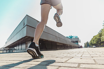 Image showing Pretty sporty woman jogging at city