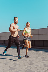 Image showing Pretty sporty woman and man jogging at city