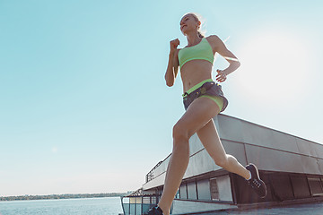 Image showing Pretty sporty woman jogging at city