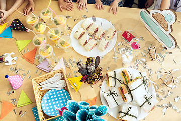 Image showing Girl birthday decorations. table setting from above with cakes, drinks and party gadgets.