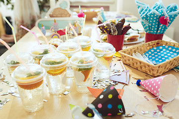 Image showing Girl birthday decorations. table setting from above with cakes, drinks and party gadgets.