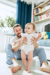 Image showing father and his baby daughter at home