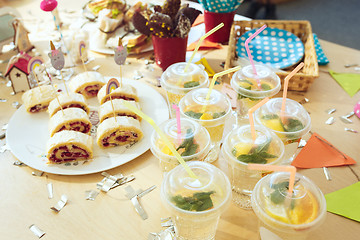 Image showing Girl birthday decorations. table setting from above with cakes, drinks and party gadgets.