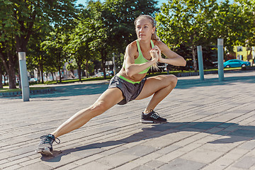 Image showing Fit fitness woman doing stretching exercises outdoors at park