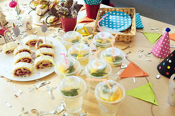 Image showing Girl birthday decorations. table setting from above with cakes, drinks and party gadgets.