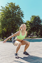 Image showing Fit fitness woman doing stretching exercises outdoors at park