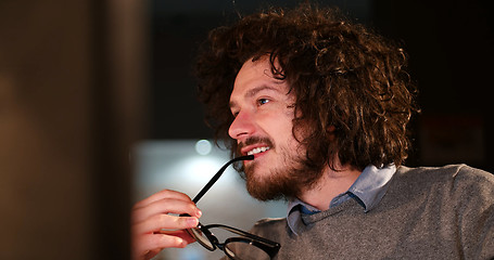 Image showing man working on computer in dark office