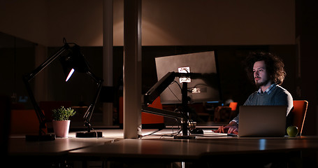 Image showing man working on computer in dark office