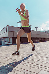 Image showing Pretty sporty woman jogging at city