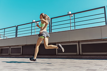 Image showing Pretty sporty woman jogging at city