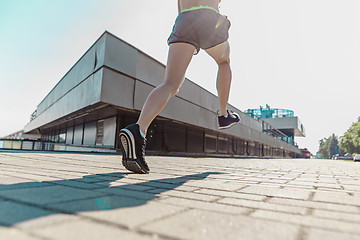 Image showing Pretty sporty woman jogging at city