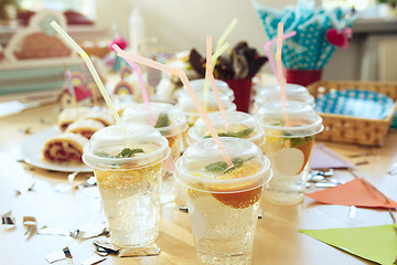 Image showing Girl birthday decorations. table setting from above with cakes, drinks and party gadgets.