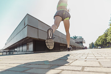 Image showing Pretty sporty woman jogging at city