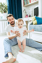 Image showing father and his baby daughter at home