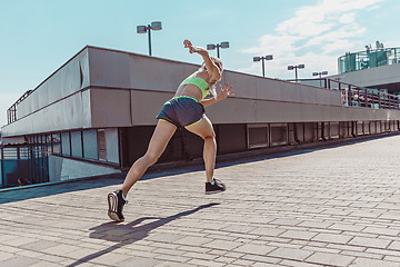 Image showing Pretty sporty woman jogging at city