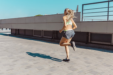 Image showing Pretty sporty woman jogging at city