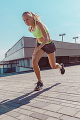 Image showing Pretty sporty woman jogging at city