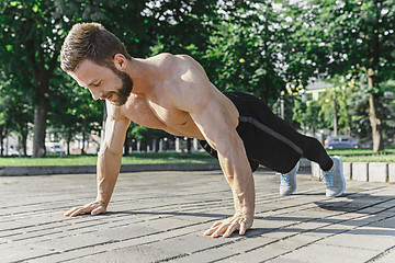 Image showing Fit fitness man doing fitness exercises outdoors at city