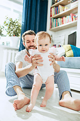 Image showing father and his baby daughter at home