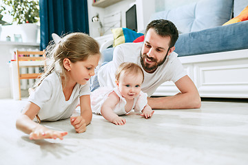 Image showing Proud father holding his newborn baby daughter at home