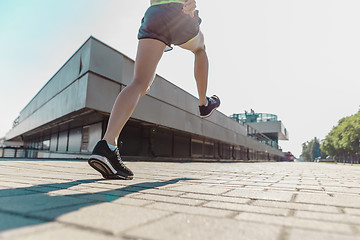 Image showing Pretty sporty woman jogging at city