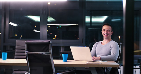 Image showing man working on laptop in dark office