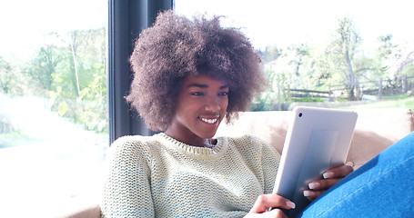 Image showing african american woman at home using digital tablet