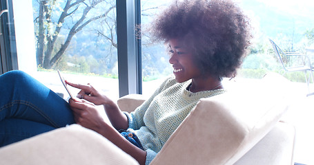 Image showing african american woman at home using digital tablet