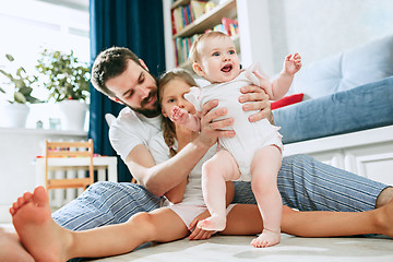 Image showing Proud father holding his newborn baby daughter at home