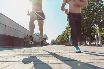 Image showing Pretty sporty woman and man jogging at city