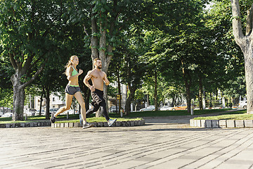 Image showing Pretty sporty woman and man jogging at city