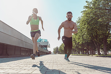 Image showing Pretty sporty woman and man jogging at city