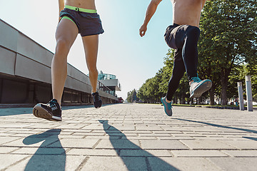 Image showing Pretty sporty woman and man jogging at city