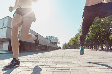 Image showing Pretty sporty woman and man jogging at city