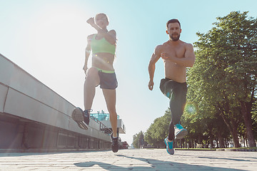 Image showing Pretty sporty woman and man jogging at city