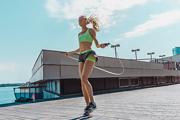 Image showing Fit fitness woman doing fitness exercises outdoors