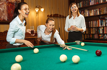 Image showing Young women playing billiards at office after work.