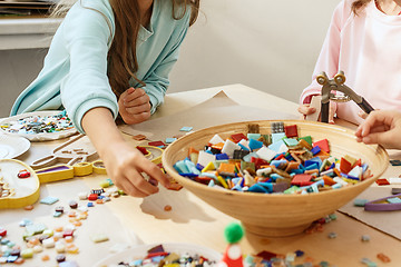 Image showing mosaic puzzle art for kids, children\'s creative game. two sisters are playing mosaic