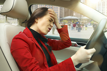 Image showing Driving around city. Young attractive woman driving a car