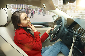 Image showing Driving around city. Young attractive woman driving a car