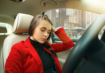 Image showing Driving around city. Young attractive woman driving a car