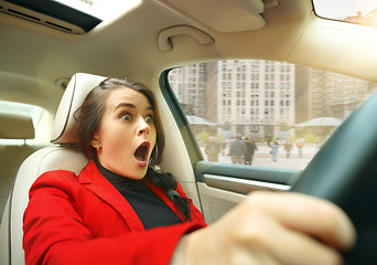 Image showing Driving around city. Young attractive woman driving a car